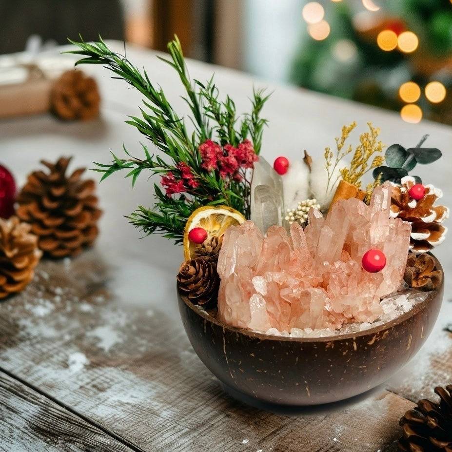 BBOBBY CRYSTAL rose quartz crystal cluster mini garden in a coconut bowl, styled on a Christmas gift table with pinecones, faux snow and warm holiday bokeh lights.